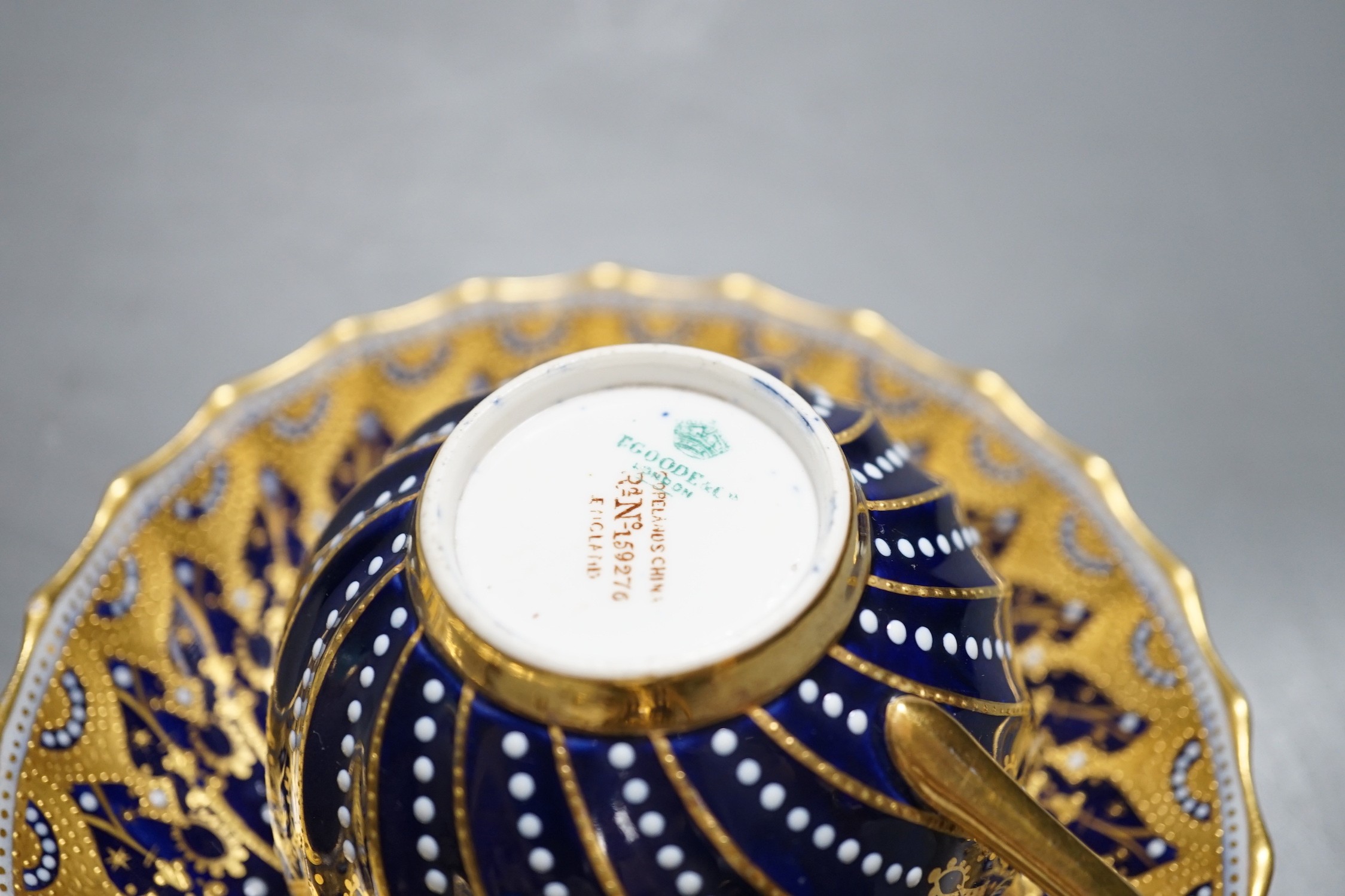 A 19th century Coalport fan shaped dish painted with a Loch scene, two small cup with twin handles decorated with raised gilding on a cobalt blue ground with crown marks, a Copeland jewelled cup and saucer with blue grou